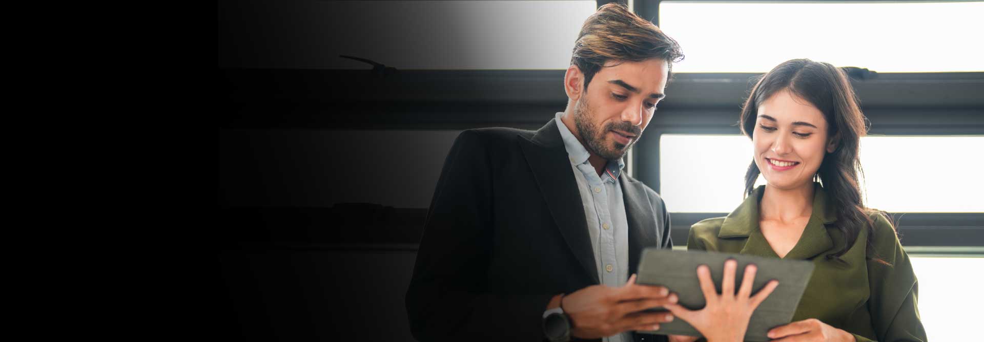 Mujer y hombre de mediana edad mirando una lista, vestido formal de ofidina, revisando el computador