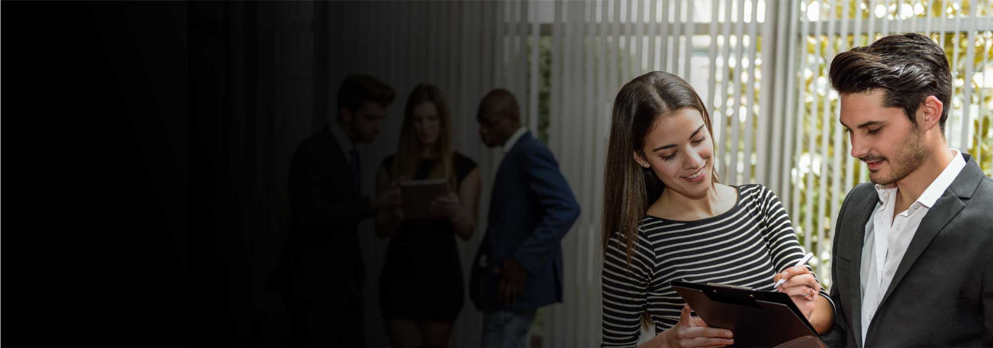 Mujer y hombre de mediana edad mirando una lista, vestido formal de ofidina